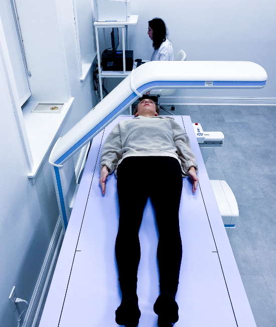 “Patient lying on a padded table during a DEXA scan for weight loss tracking at NYC performance lab”