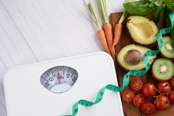 Weight scale with a cutting board of vegetables and a measuring tape