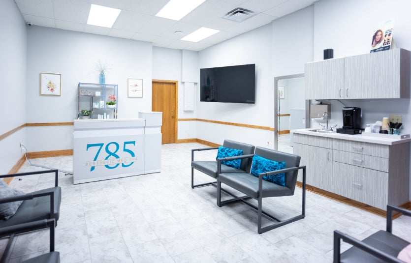 Modern waiting room with reception desk, chairs, and a TV.