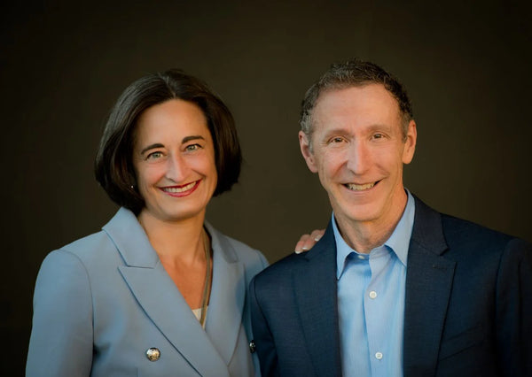 Two people posing for a portrait against a dark background